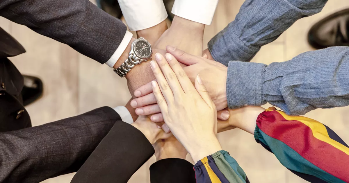 円陣で重ねられたチームの手と手